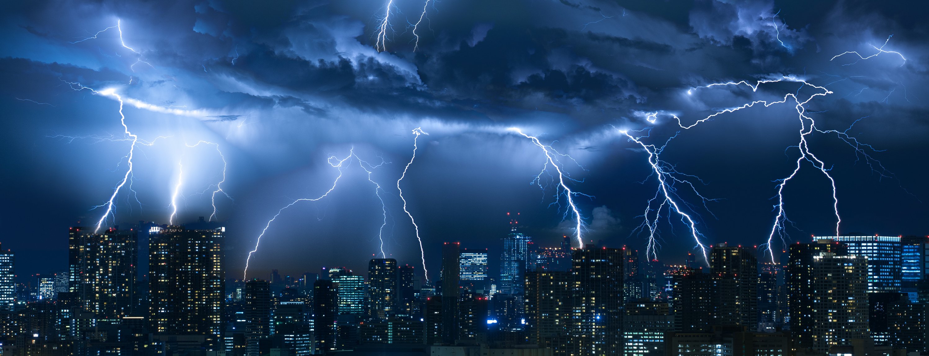 Lightning storm over city in blue light